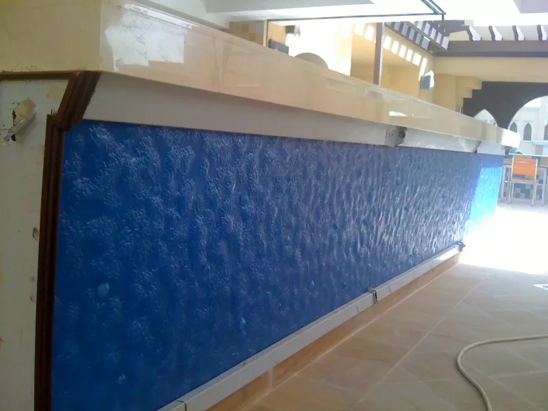 Blue textured glass bar counter front panel under a marble top