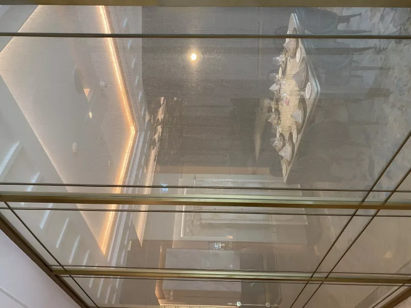 Brass-framed glass partition enclosing a restaurant dining area