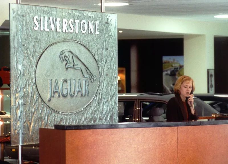 Corporate logo panel in textured cast glass with raised lettering on stainless steel rods