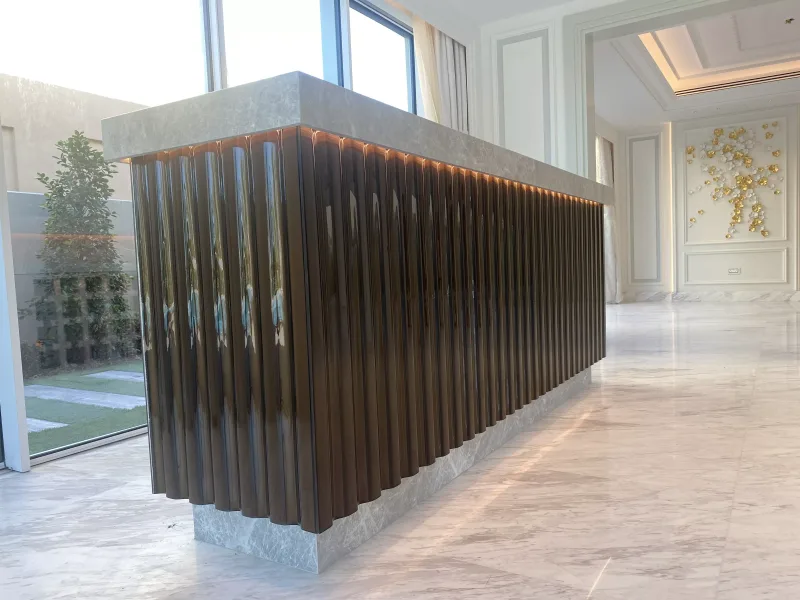 Fluted smoked glass counter front with marble top and warm LED lighting in a luxury villa