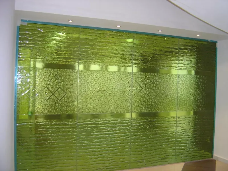 Green cast glass feature wall with textured bands and a circle and diamond pattern