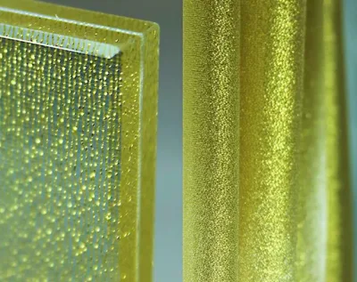 Gold fabric laminated glass sample showing textured fabric interlayer between toughened glass panes
