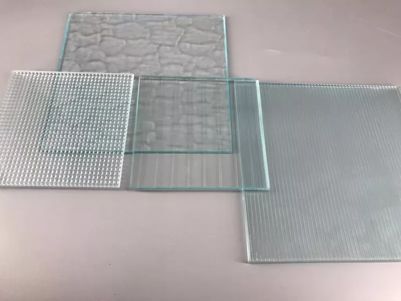 Clear patterned glass samples showing reeded, fluted, grid and stone-textured finishes